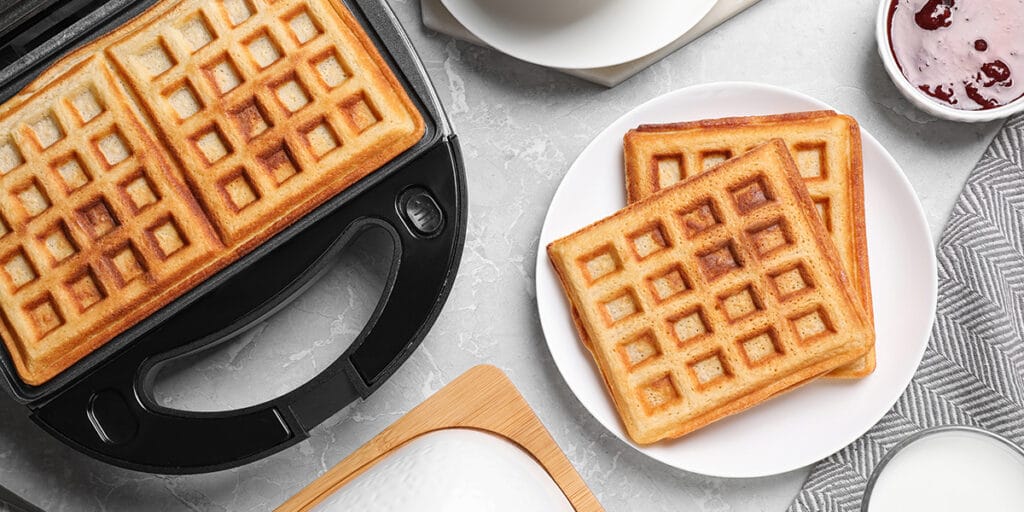 Tabakta kare şeklinde waffle ve reçeli görseli.