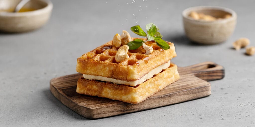Ahşap tahtanın üzerinde kaju kremalı, karamel soslu waffle tarif görseli